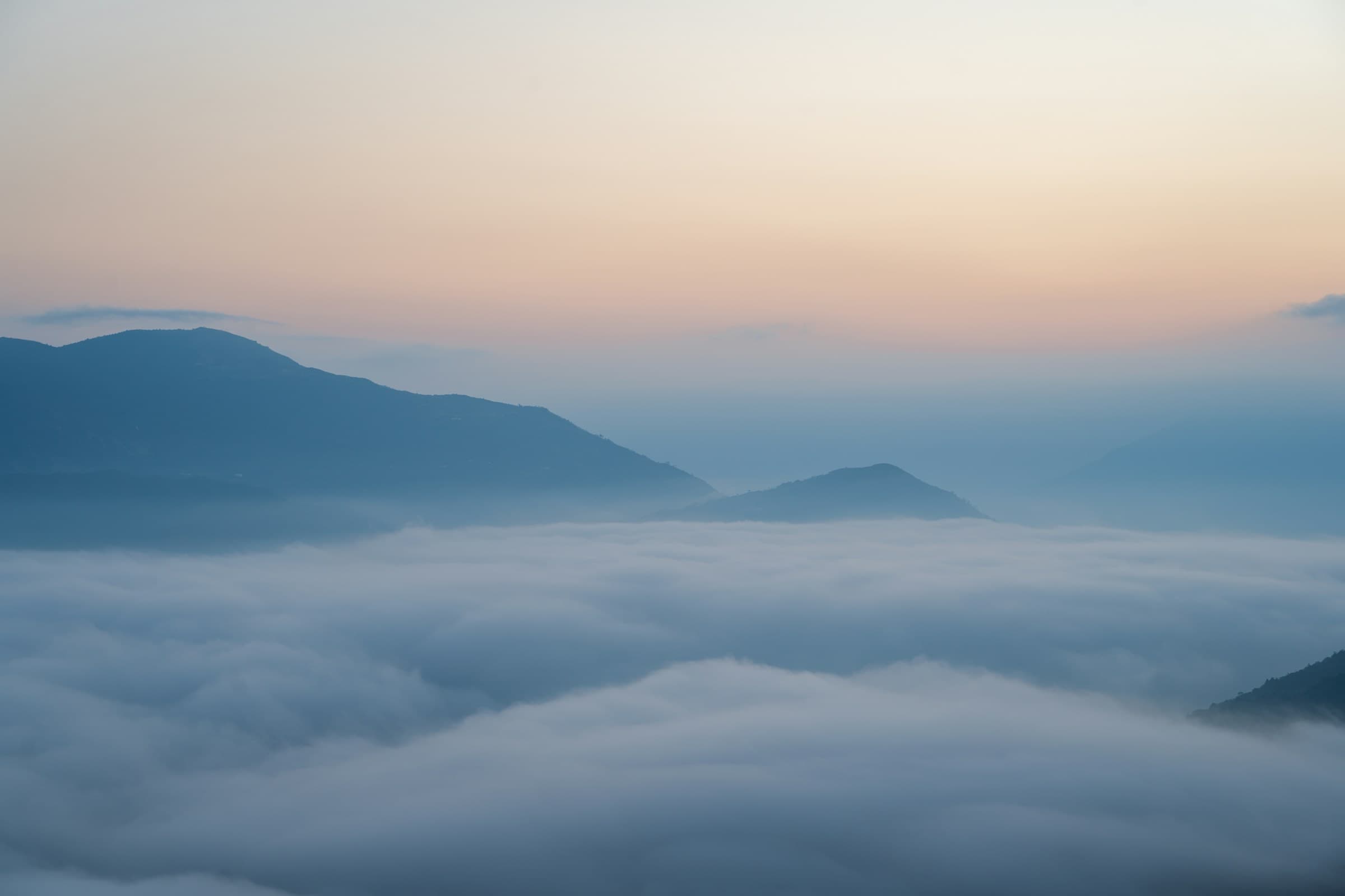 夜明けに雲の海から山々が現れる